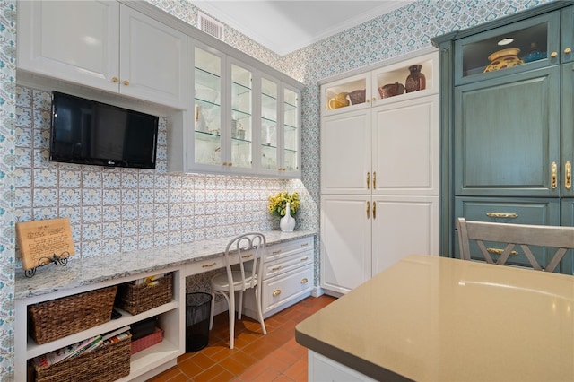 kitchen with white cabinetry, light stone countertops, and ornamental molding