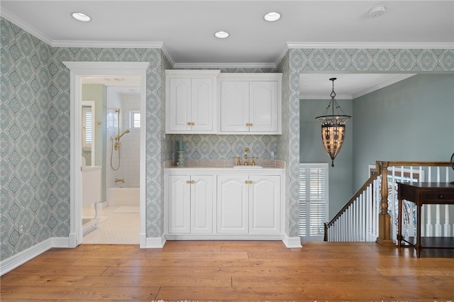 bar with plenty of natural light, light wood-type flooring, decorative light fixtures, and white cabinets