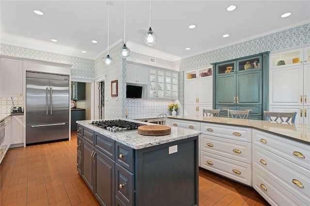 kitchen with ornamental molding, stainless steel appliances, white cabinetry, and a kitchen island