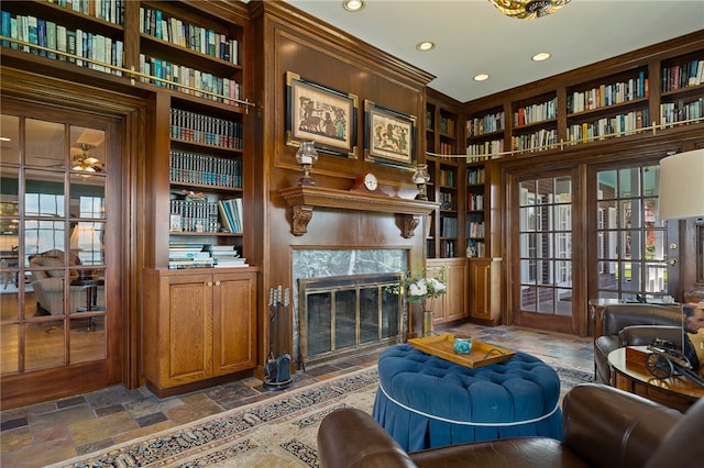 living area featuring built in shelves and a high end fireplace