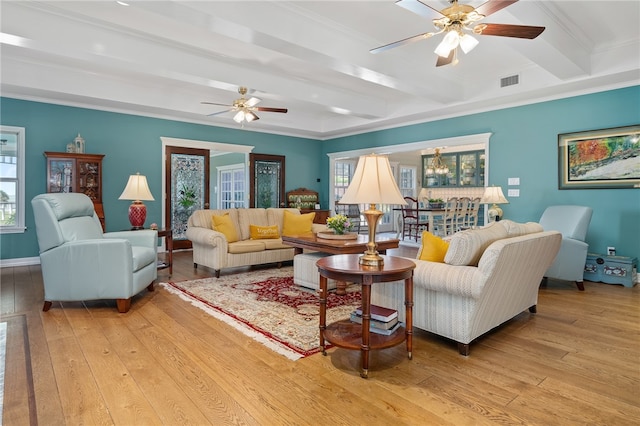 living room featuring light hardwood / wood-style floors, a healthy amount of sunlight, ceiling fan, and beam ceiling