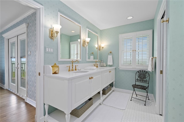 bathroom featuring ornamental molding, a wealth of natural light, wood-type flooring, and vanity