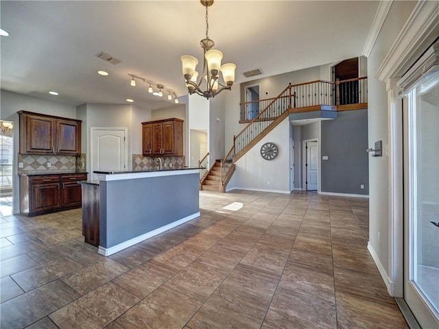 kitchen featuring backsplash, plenty of natural light, decorative light fixtures, and a notable chandelier