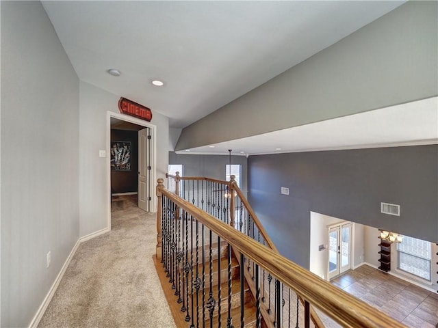 hallway featuring light carpet and lofted ceiling