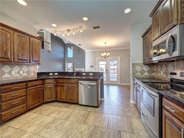 kitchen featuring tasteful backsplash, sink, hanging light fixtures, and appliances with stainless steel finishes