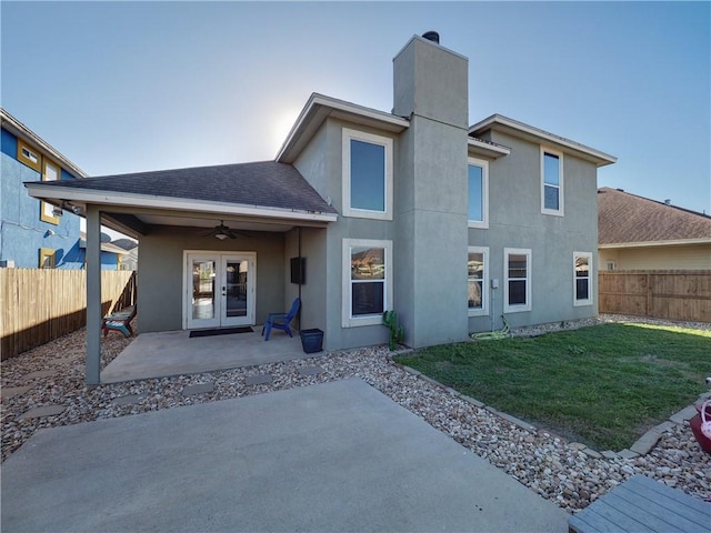 rear view of property with a lawn, ceiling fan, french doors, and a patio