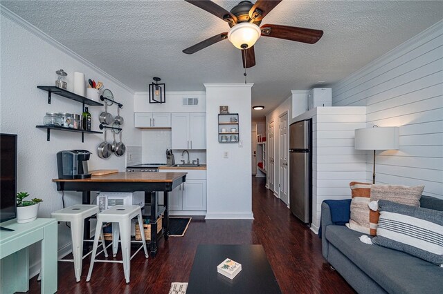 3938 Surfside Blvd Unit 3116, Corpus Christi, TX 78402 - living room featuring a textured ceiling, a ceiling fan, dark wood finished floors, and ornamental molding