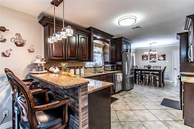 4009 Rooney Dr, Corpus Christi, TX 78413 - kitchen with stainless steel appliances, dark brown cabinetry, a sink, a peninsula, and ornamental molding