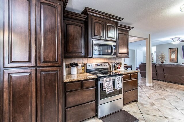 4009 Rooney Dr, Corpus Christi, TX 78413 - kitchen with stainless steel appliances, a ceiling fan, dark brown cabinetry, open floor plan, and light stone counters