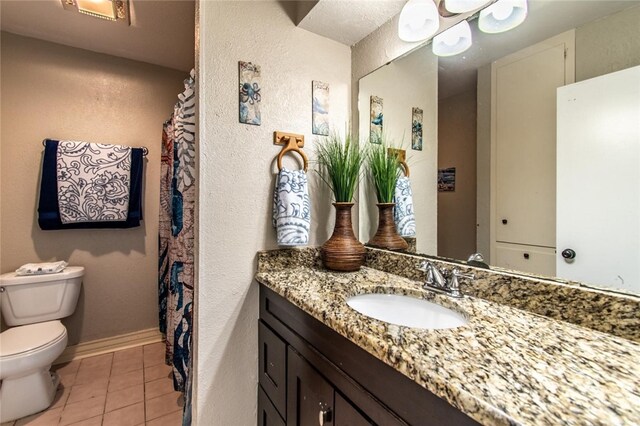 4009 Rooney Dr, Corpus Christi, TX 78413 - full bathroom with toilet, vanity, tile patterned flooring, a textured wall, and baseboards