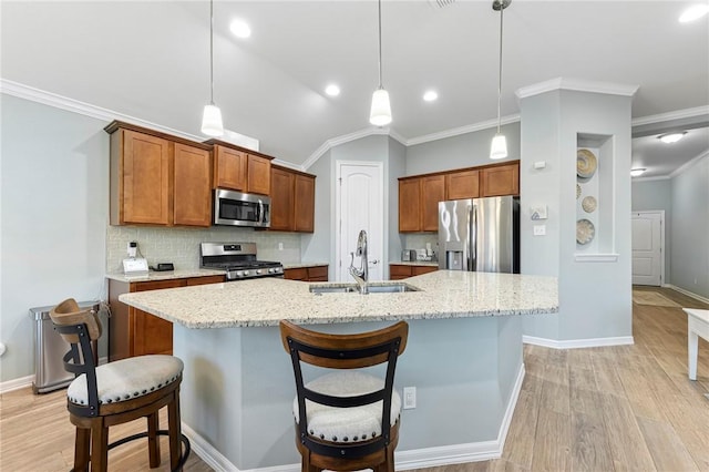 kitchen with tasteful backsplash, a center island with sink, light wood-style flooring, stainless steel appliances, and a sink