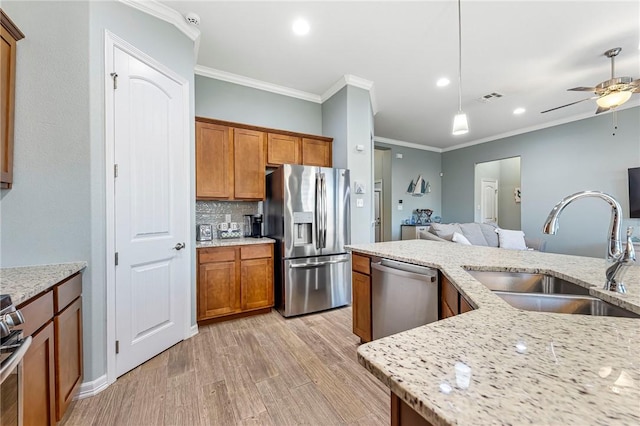 kitchen with brown cabinetry, visible vents, appliances with stainless steel finishes, and a sink