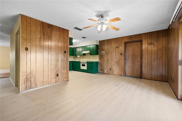3265 W Susan Cir, Ingleside, TX 78362 - unfurnished living room featuring light wood-style floors, wooden walls, and ceiling fan