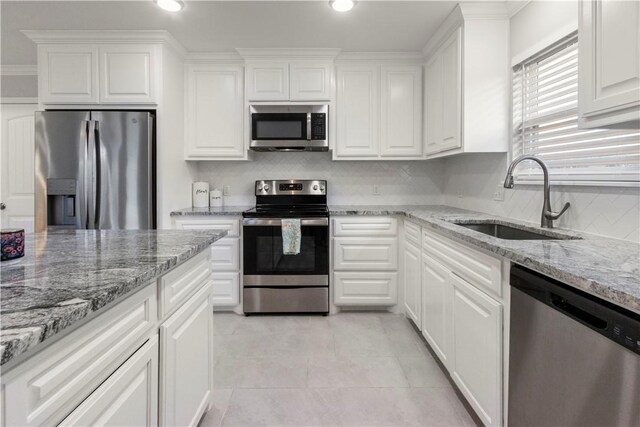 1501 Days End Dr, Corpus Christi, TX 78417 - kitchen with appliances with stainless steel finishes, decorative backsplash, white cabinets, light tile patterned floors, and recessed lighting