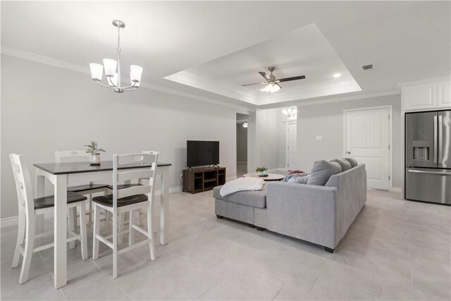 1501 Days End Dr, Corpus Christi, TX 78417 - living room featuring a ceiling fan, a tray ceiling, a chandelier, ornamental molding, and light tile patterned floors