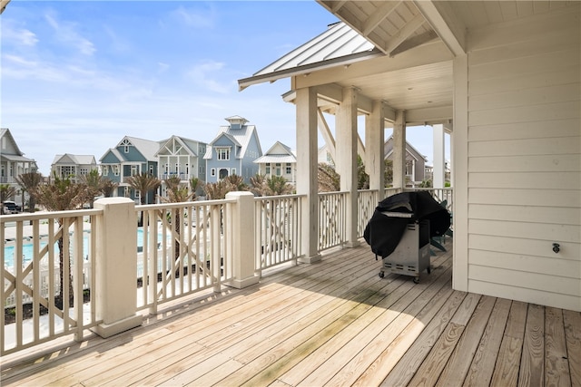 wooden terrace featuring a swimming pool and grilling area