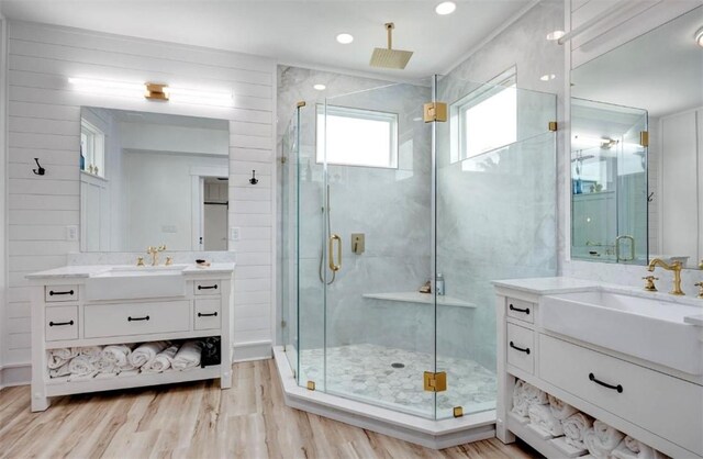 1227 S Magnolia St, Rockport, TX 78382 - bathroom featuring a stall shower, wood finished floors, two vanities, and a sink
