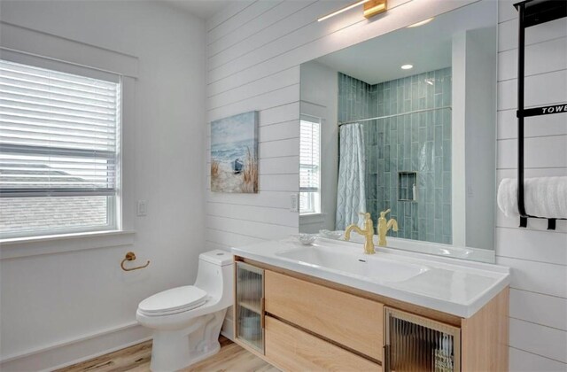 1227 S Magnolia St, Rockport, TX 78382 - full bathroom featuring vanity, wooden walls, toilet, a tile shower, and wood finished floors