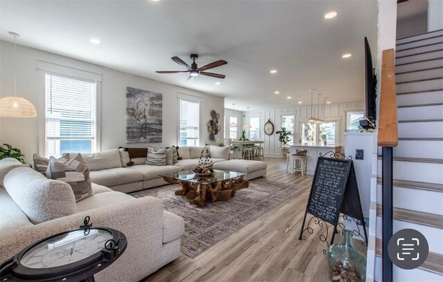 1227 S Magnolia St, Rockport, TX 78382 - living room with light wood-style flooring, a healthy amount of sunlight, a ceiling fan, and stairs