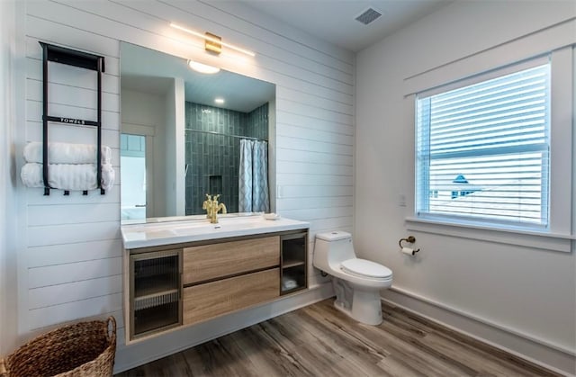 1227 S Magnolia St, Rockport, TX 78382 - full bath with visible vents, a tile shower, toilet, vanity, and wood finished floors