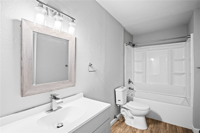 2630 Lynch St, Corpus Christi, TX 78404 - bathroom featuring wood finished floors, toilet, vanity, shower / washtub combination, and a textured wall