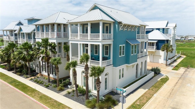 view of side of property with metal roof, a standing seam roof, and a balcony