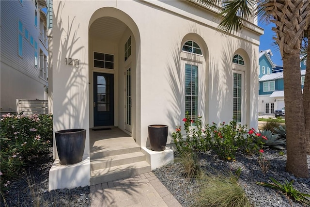 doorway to property featuring stucco siding
