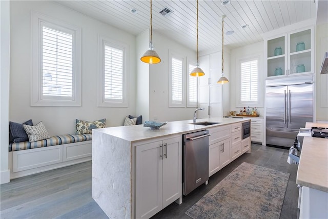 kitchen featuring a sink, stainless steel appliances, white cabinetry, dark wood-style floors, and wood ceiling