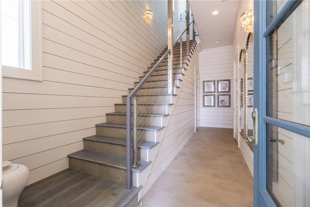 stairway featuring wooden walls, recessed lighting, and wood finished floors