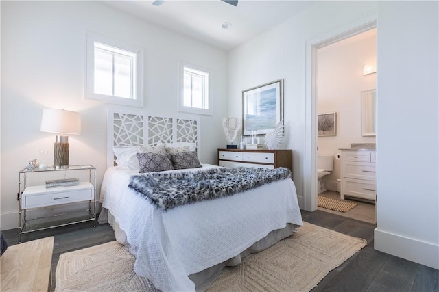 bedroom with ensuite bathroom and dark wood-type flooring