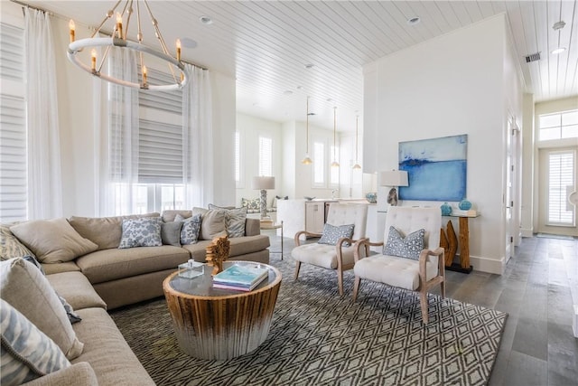 living area featuring wood ceiling, wood finished floors, visible vents, baseboards, and a chandelier