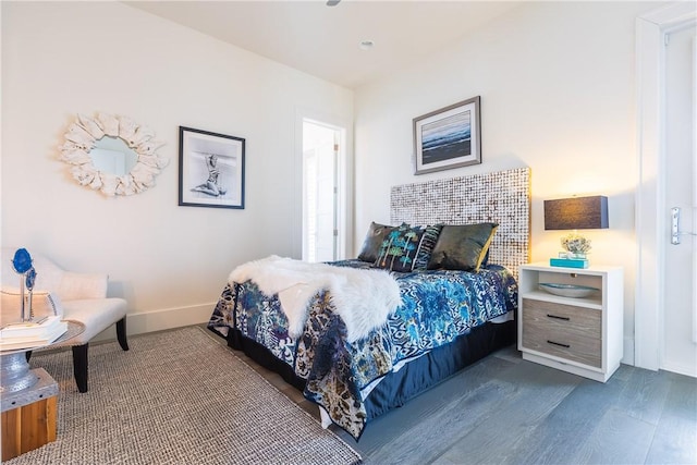 bedroom with baseboards and dark wood-style floors