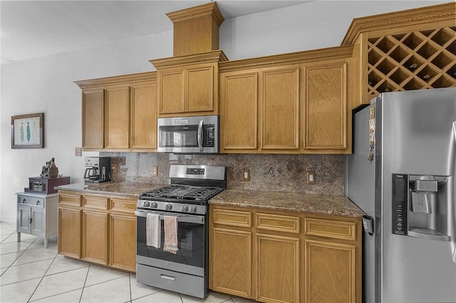 15426 Cuttysark St, Corpus Christi, TX 78418 - kitchen featuring stainless steel appliances, decorative backsplash, light tile patterned floors, dark stone countertops, and brown cabinetry