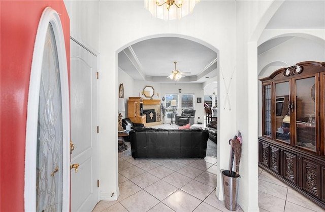 15426 Cuttysark St, Corpus Christi, TX 78418 - foyer featuring light tile patterned floors, a tray ceiling, ceiling fan, arched walkways, and a fireplace