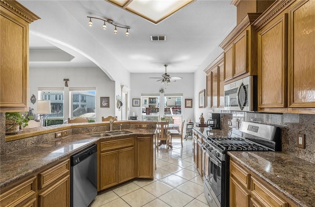 15426 Cuttysark St, Corpus Christi, TX 78418 - kitchen featuring appliances with stainless steel finishes, brown cabinets, a ceiling fan, decorative backsplash, and healthy amount of natural light