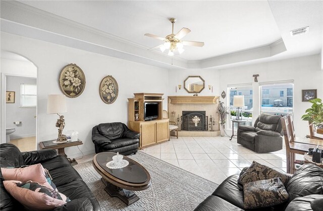15426 Cuttysark St, Corpus Christi, TX 78418 - living room featuring ceiling fan, arched walkways, a raised ceiling, a premium fireplace, and light tile patterned floors
