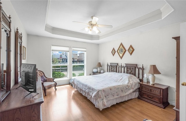 15426 Cuttysark St, Corpus Christi, TX 78418 - bedroom featuring a tray ceiling, light wood finished floors, crown molding, a barn door, and ceiling fan