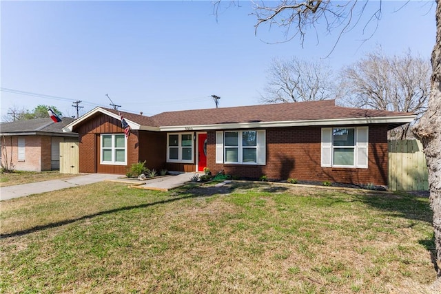 single story home with a front lawn, fence, brick siding, and a shingled roof