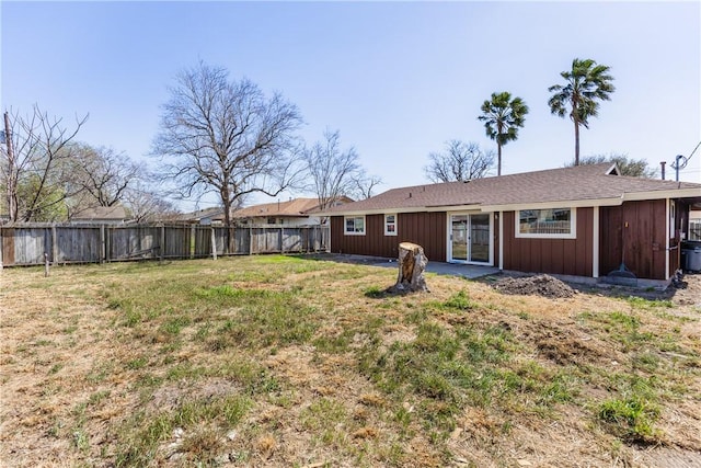 rear view of property with a lawn and fence