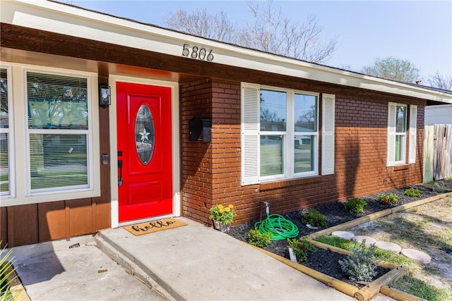 view of exterior entry featuring brick siding