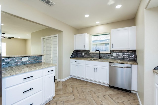 kitchen featuring visible vents, light stone countertops, decorative backsplash, stainless steel dishwasher, and a sink