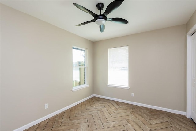 interior space with a wealth of natural light, baseboards, and a ceiling fan