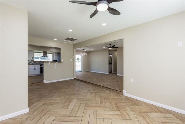 spare room featuring a ceiling fan, recessed lighting, visible vents, and baseboards