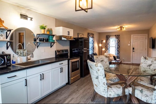 109 S Verne St, Rockport, TX 78382 - kitchen with open shelves, stainless steel range with electric stovetop, under cabinet range hood, wood finished floors, and dark countertops