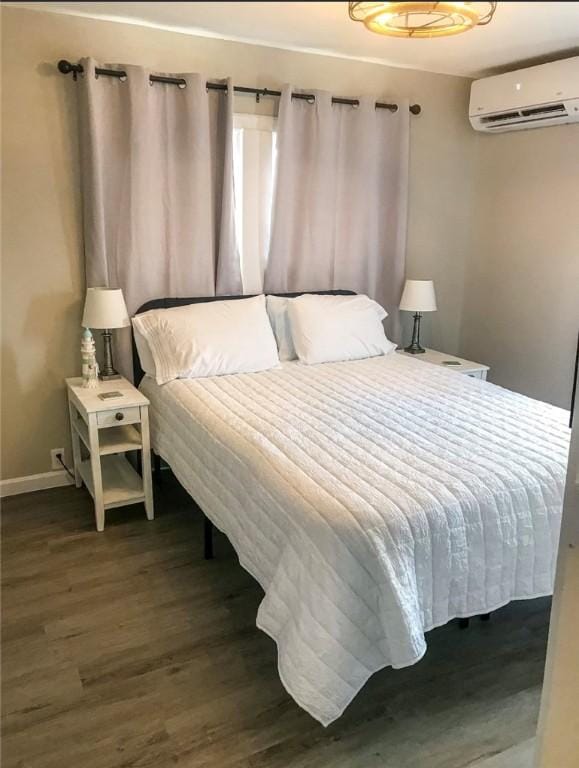 109 S Verne St, Rockport, TX 78382 - bedroom featuring a wall unit AC and dark wood-style flooring