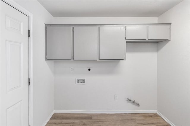 laundry area featuring hardwood / wood-style floors, cabinets, hookup for a gas dryer, washer hookup, and hookup for an electric dryer