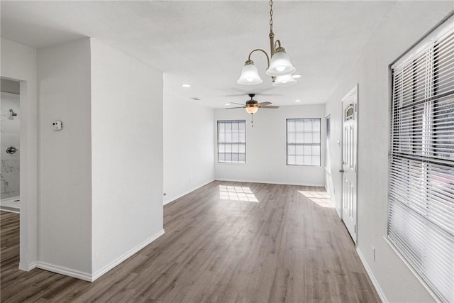 interior space featuring hardwood / wood-style flooring and ceiling fan with notable chandelier