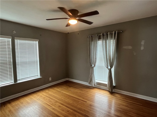 unfurnished room featuring a wealth of natural light, ceiling fan, and light hardwood / wood-style flooring