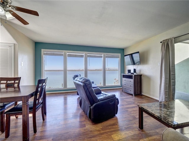 living area with a ceiling fan and dark wood finished floors