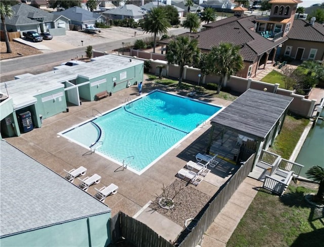 community pool with a patio, fence private yard, and a residential view